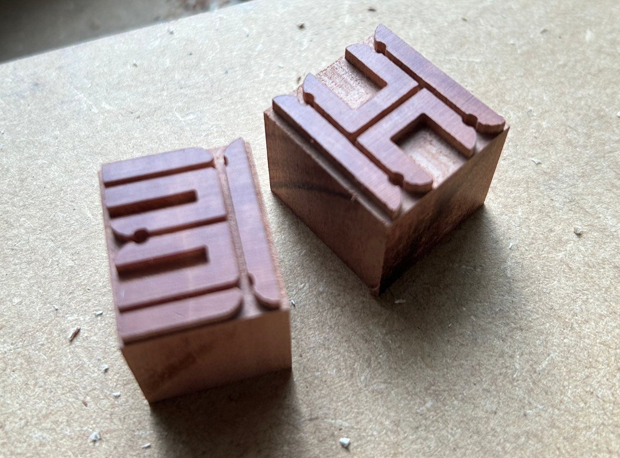 Two wooden stamps with engraved characters.