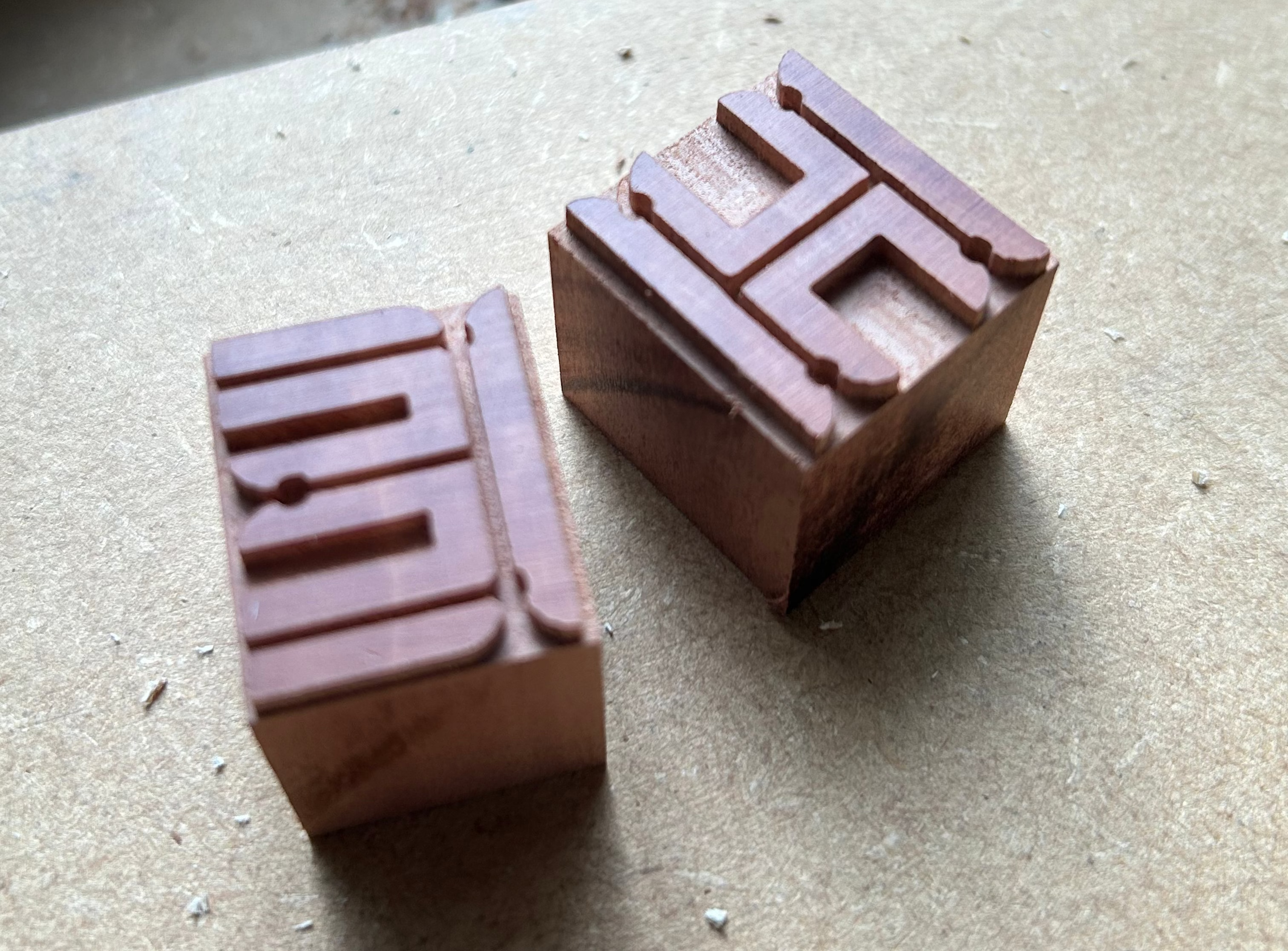 Two wooden stamps with engraved characters.
